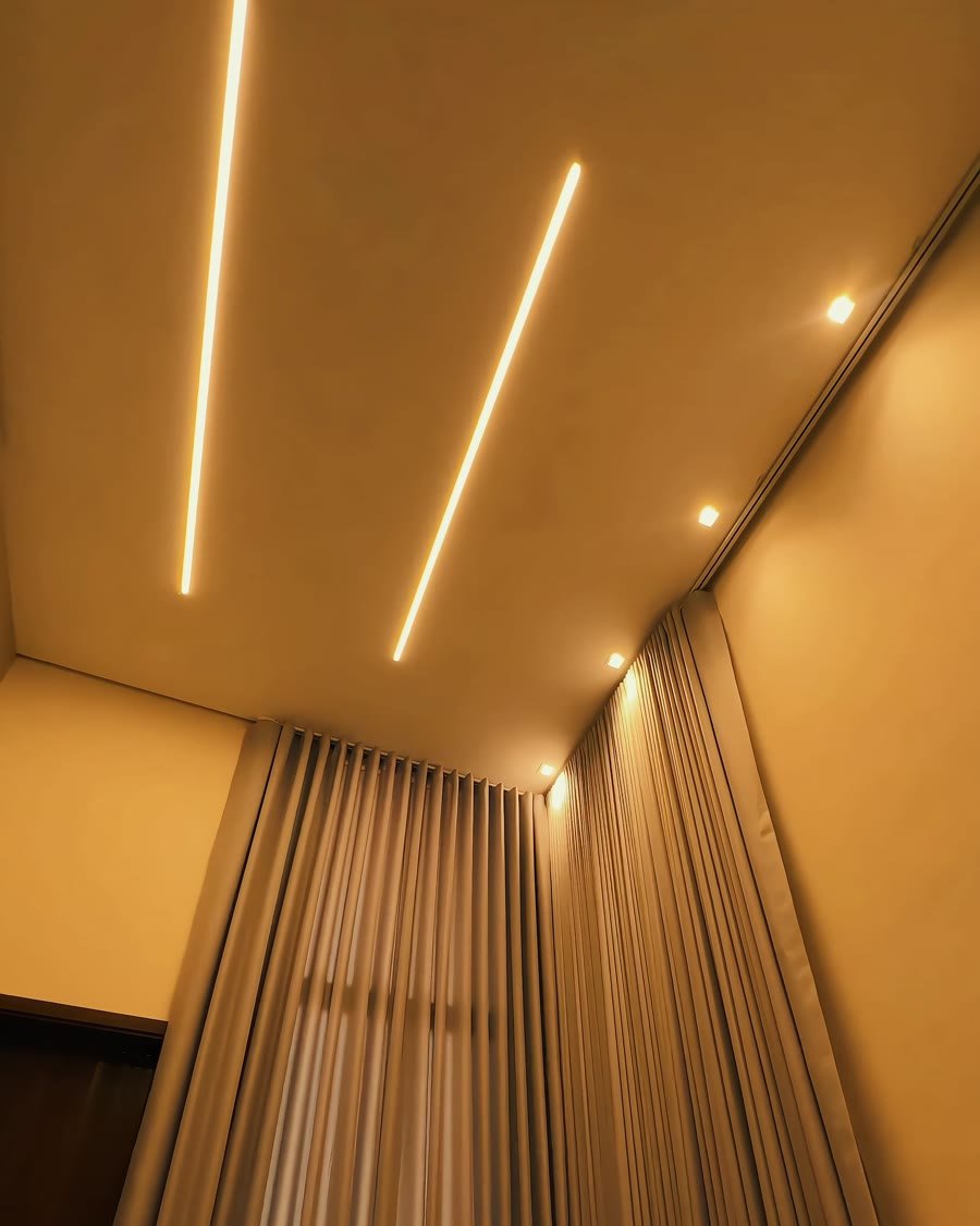 Perfis de LED no teto e cortinas
